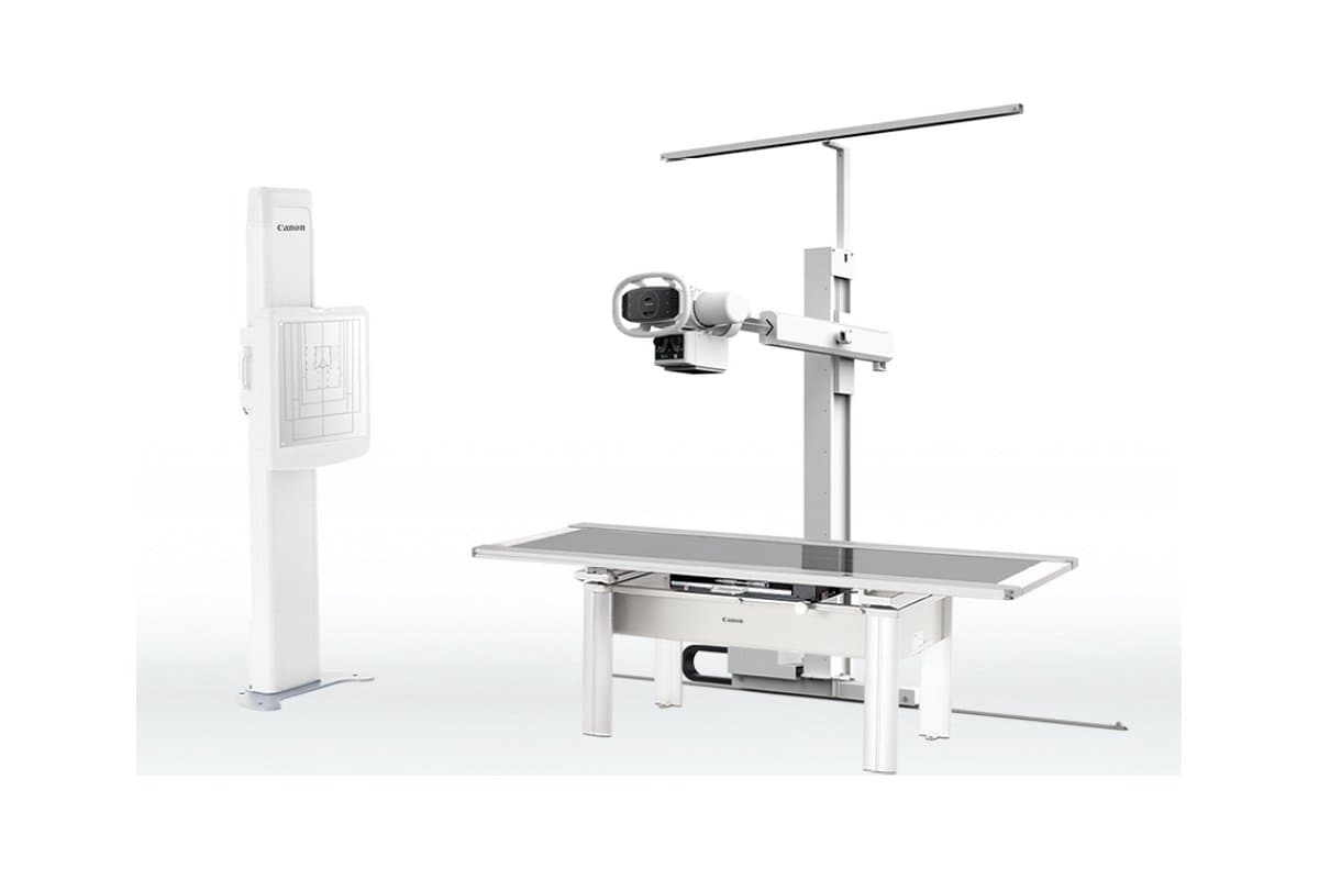 A Canon RADREX digital X-ray room: wall-stand detector, X-ray tube on a floor stand, and patient table